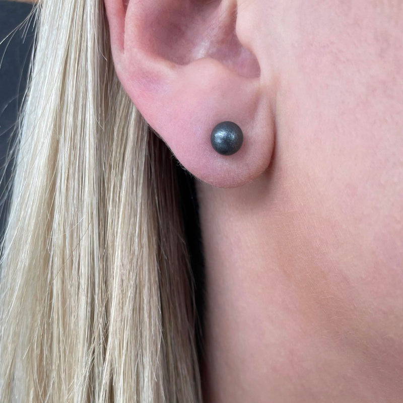 Asymmetrical earrings with bullet
