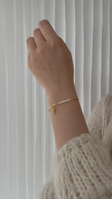 Armring med perletop og mini fjer charm